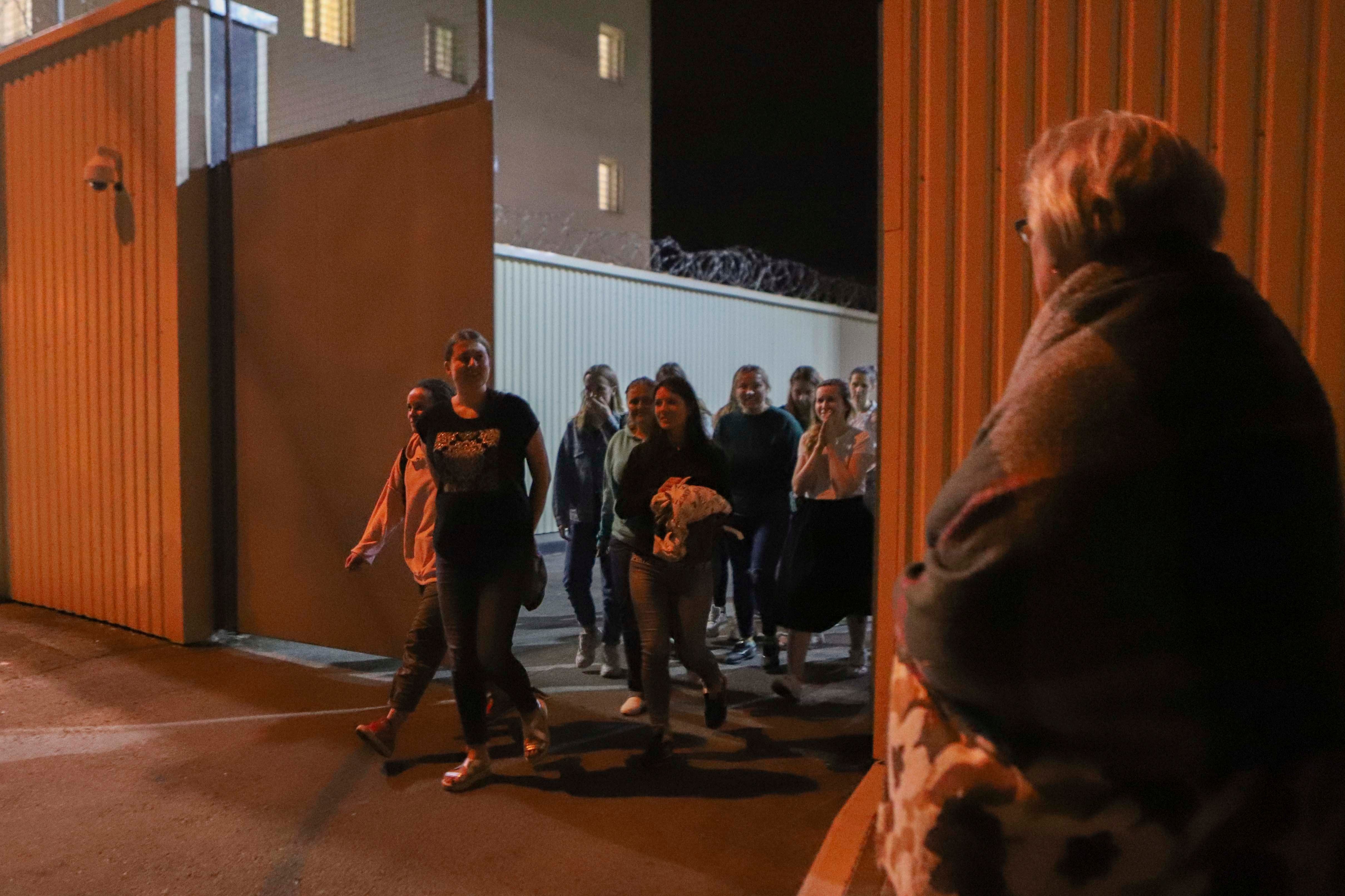 Women walk through a gate on Friday, Aug. 14, 2020, after being released from a detention center where they were detained following protests of the disputed presidential election in Minsk, Belarus. 