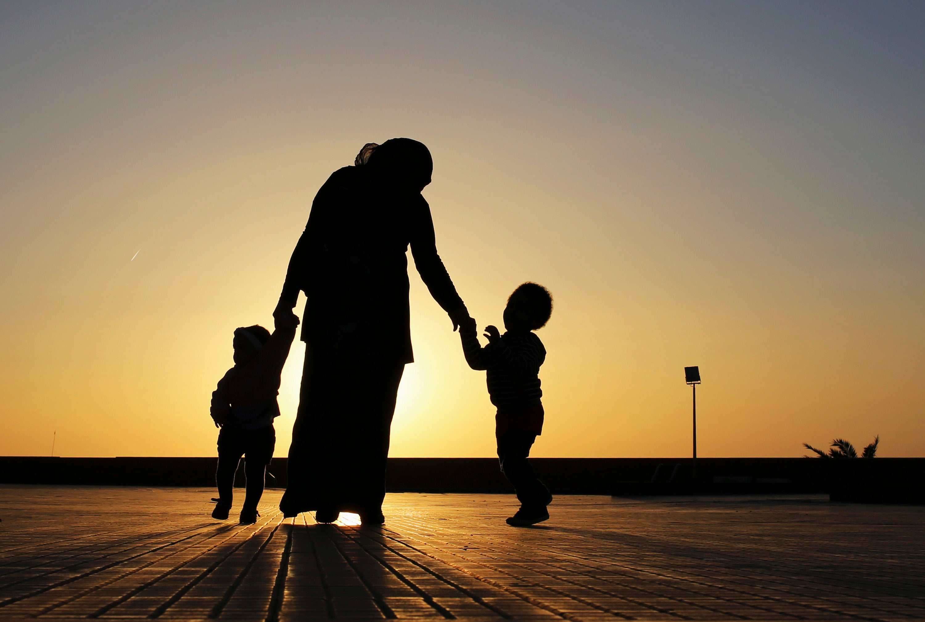 A woman walks with her two children at sunset near the seashore in Benghazi.