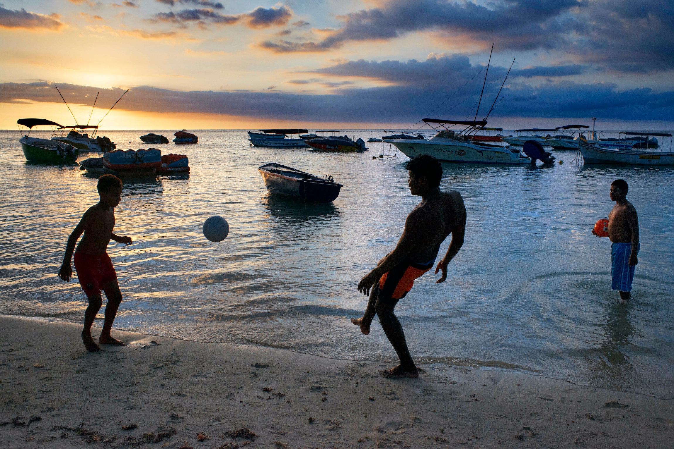Children playing at sunset at Trou aux Biches in Mauritius. 