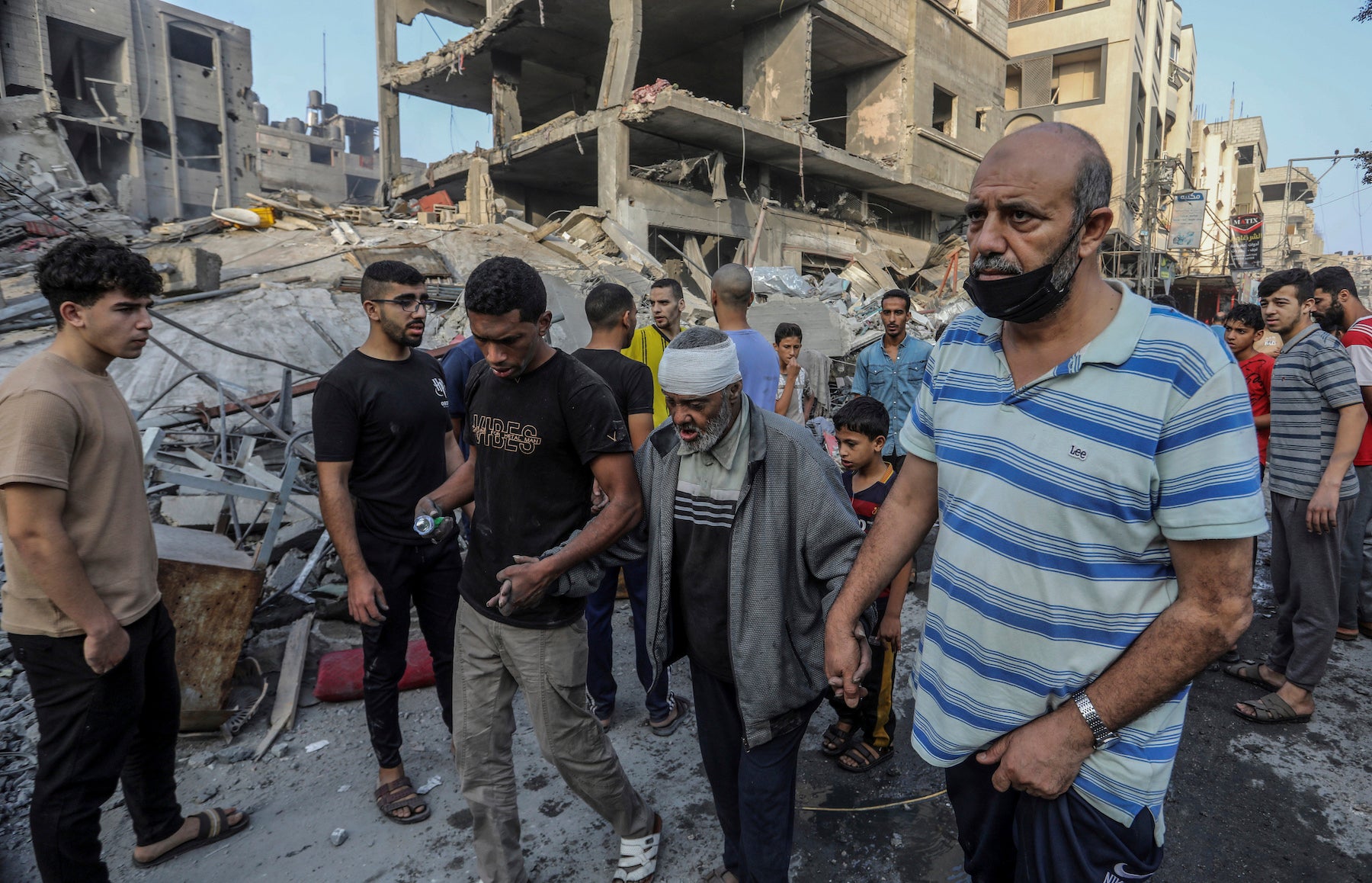 Palestinians help an injured older man following overnight Israeli air strikes on the Rafah refugee camp in Gaza, October 25, 2023.
