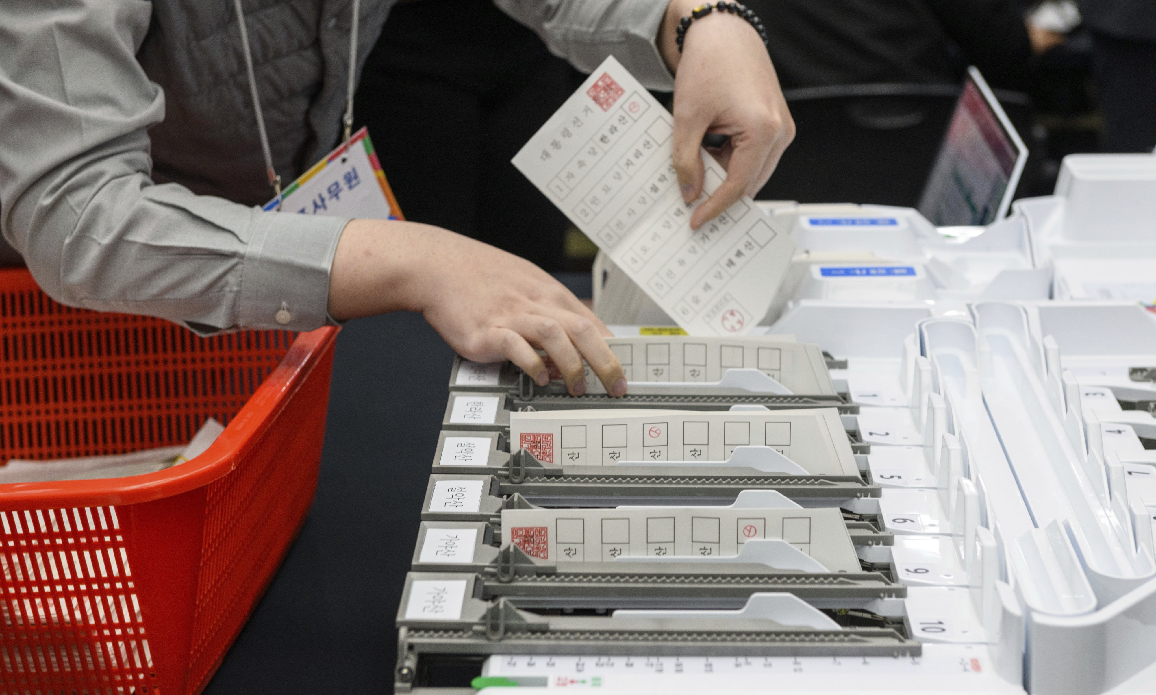 An official demonstrates the ballot counting process using a ballot sorting machine during a simulation of the presidential election voting and counting procedures at South Korea's National Election Commission, April 10, 2025. 