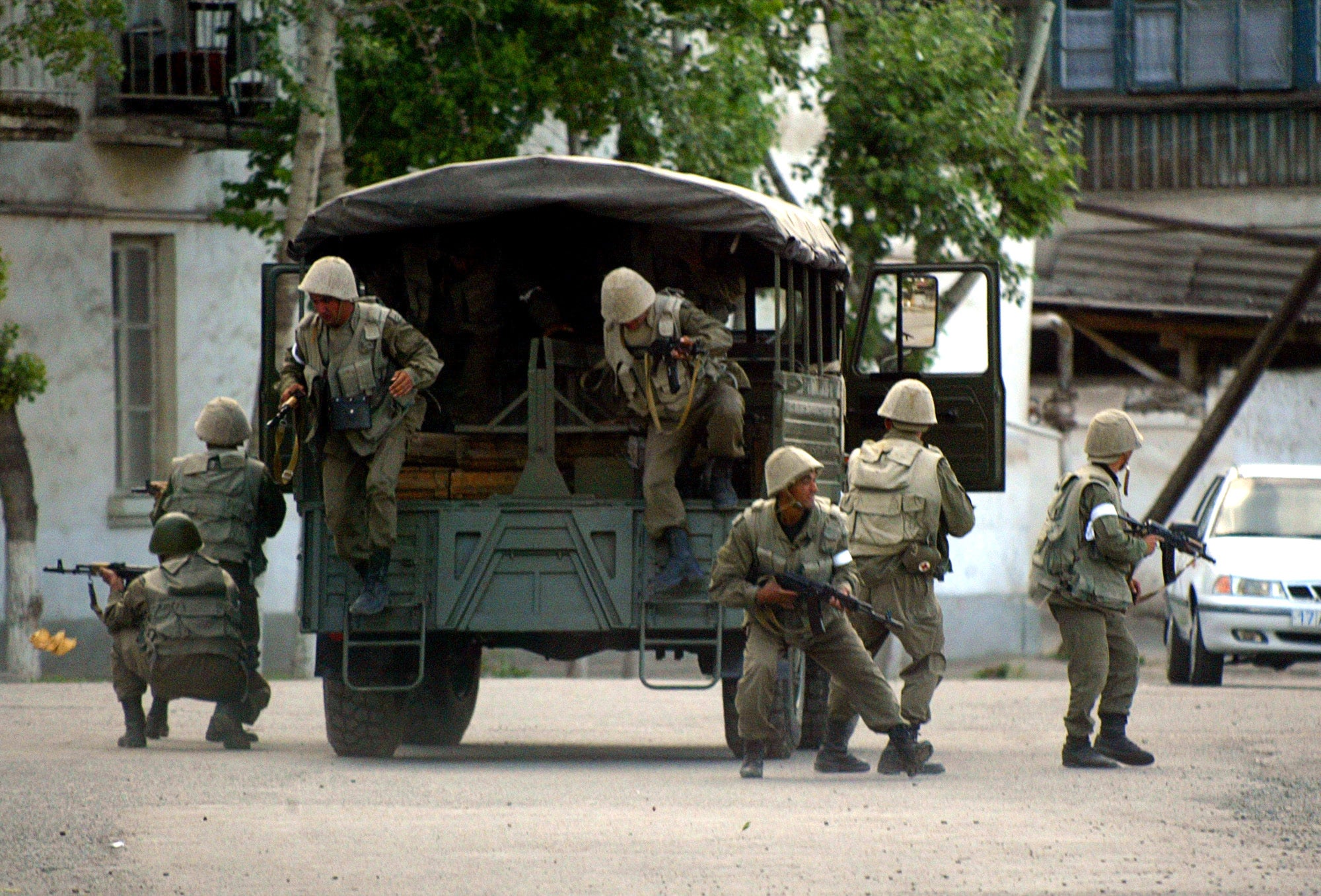 Soldiers jump out of a truck in the city of Andijan, Uzbekistan on May 13, 2005, where that day security forces opened fire on overwhelmingly peaceful protestors, killing hundreds and wounding more.