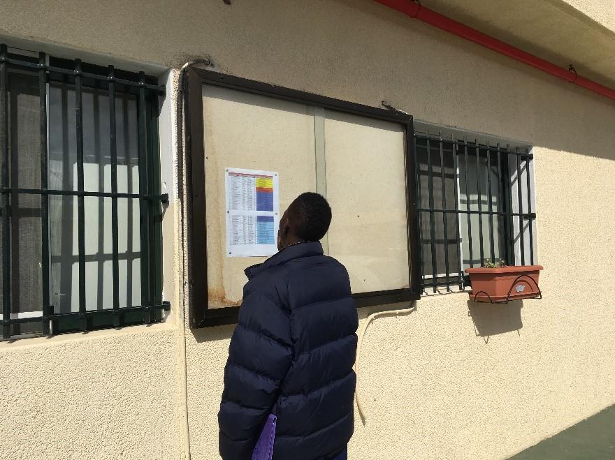 Migrant looking at list of people to be transferred from Ceuta to mainland Spain, March 2017