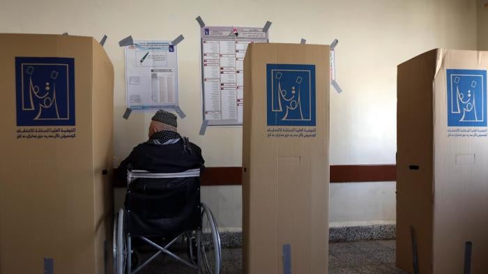 A man in a wheelchair at a voting booth
