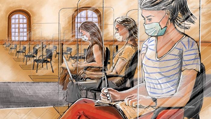 Women in face masks take notes while seated