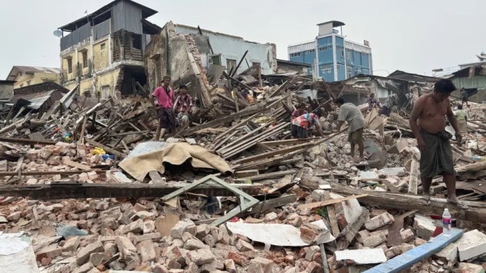 People clean debris from damaged buildings in the aftermath of an earthquake on March 28, in Naypydaw, Myanmar, April 7, 2025.