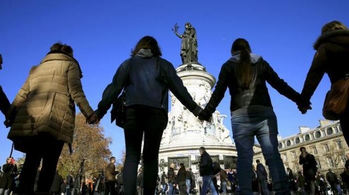 People hold hands to form a human solidarity chain near the site of the attack at the Bataclan concert hall in Paris