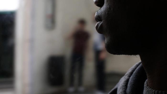 A photo showing one of the migrant teens sleeping in the street in France.