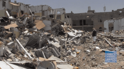 A man stands in front of the ruins of a house hit by a Saudi-led coalition strike.