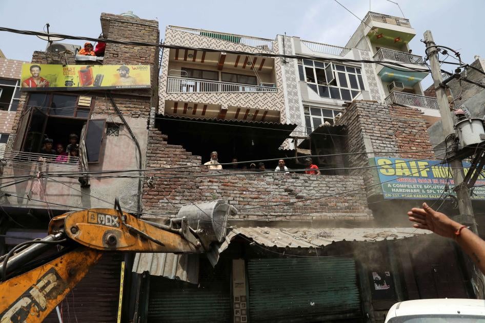 A bulldozer demolishes a shop entrance in Jahangirpuri, in New Delhi, India, April 20, 2022.