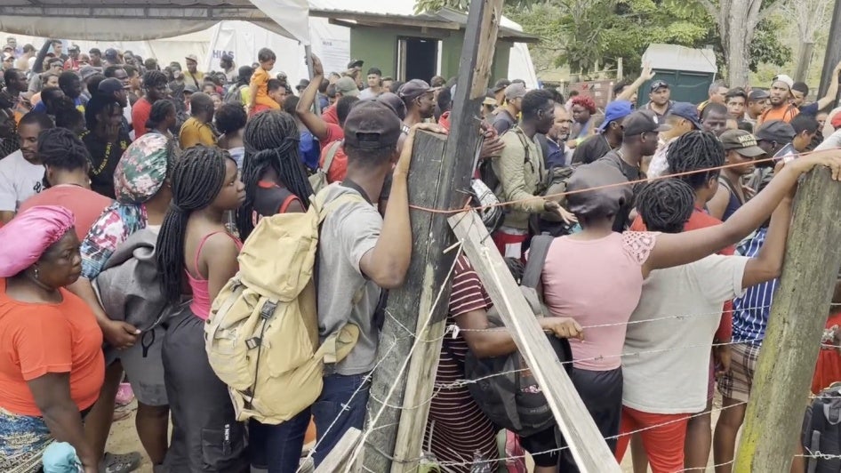 A crowd of migrants waiting for a bus