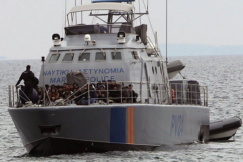 Migrants aboard a police patrol boat at sea