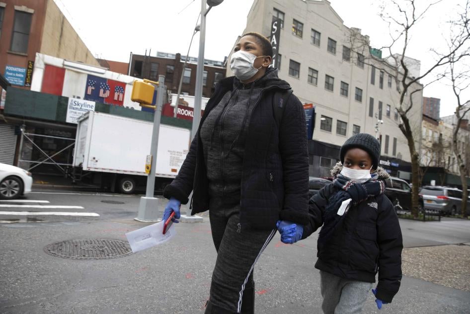 刚领到工资支票的餐厅雇员牵着孩子回家，美国纽约布鲁克林区，2020年3月19日。该餐饮业者因疫情关闭四家店面，辞退650到850名员工。