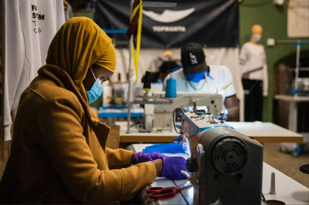 A woman using a sewing machine to make protective masks