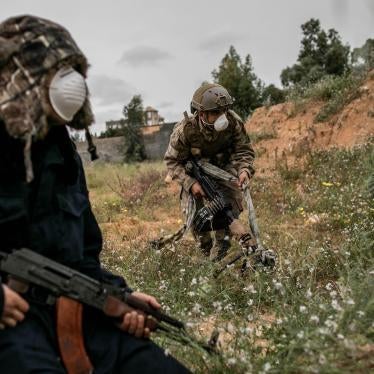 Three men in full combat gear wearing protective face masks against Covid-19, in Tripoli, Libya on March 25, 2020.