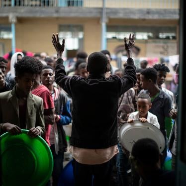An organizer asks displaced Tigrayans to queue as they wait to receive food at a school in Mekele, in Ethiopia's northern Tigray region, May 5, 2021.