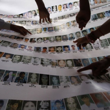 Nepalese human rights activists and relatives point to photographs of disappeared persons at an event to mark the International Day of the Disappeared, in Kathmandu, August 30, 2011. 