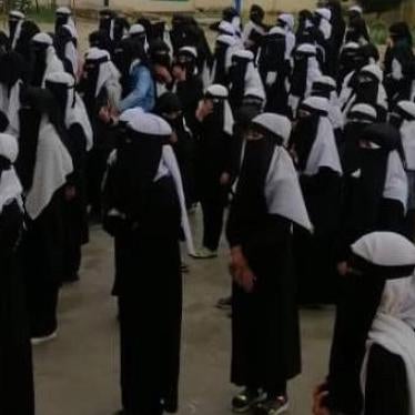 Girls stand outside while attending school