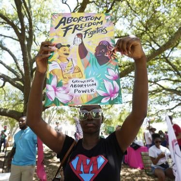 A protester holds a sign that reads "Abortion Freedom Fighters" and "Growing Abortion Power"