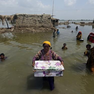 Women carry belongings salvaged from their flooded homes after monsoon rains in the Qambar Shahdadkot district of Sindh province, Pakistan, September 6, 2022.