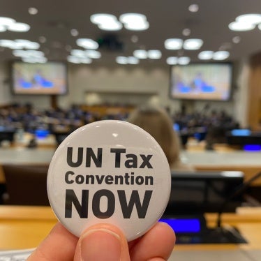 An activist holds up a button as negotiations for the tax convention take place at the United Nations in New York, February 6, 2025. 