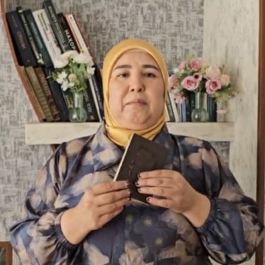 Sharifa Madrakhimova holding her destroyed passport in Uzbekistan, May 2025.