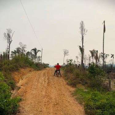 A man rides a motorcycle down a dirt road