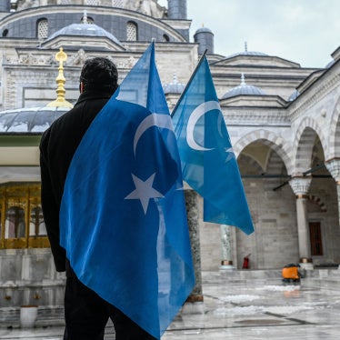 A man holding flags outside of a mosque
