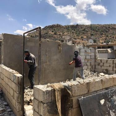 Men work to dismantle the walls of a shelter in a Syrian refugee camp in Arsal, Lebanon.